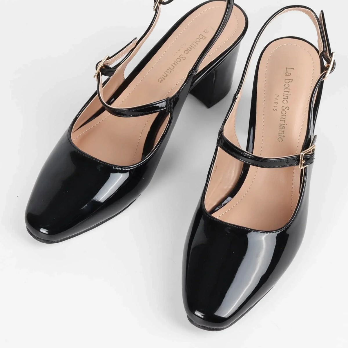 Escarpins slingback noirs vernis femme à talon bloc et boucles dorées portés par mannequin